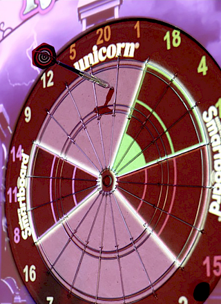 The image shows an electronic dartboard game interface with scores, a player's name, and a unicorn-themed design in the background.