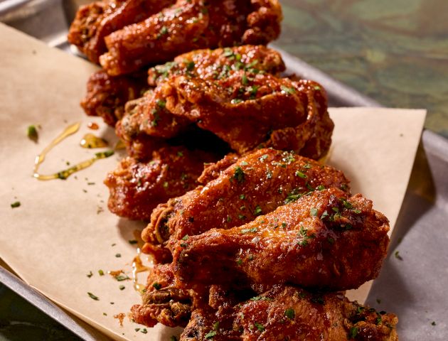 Grilled skewers of meat on a plate, likely kebabs, served with a white sauce&mdash;delicious and savory.